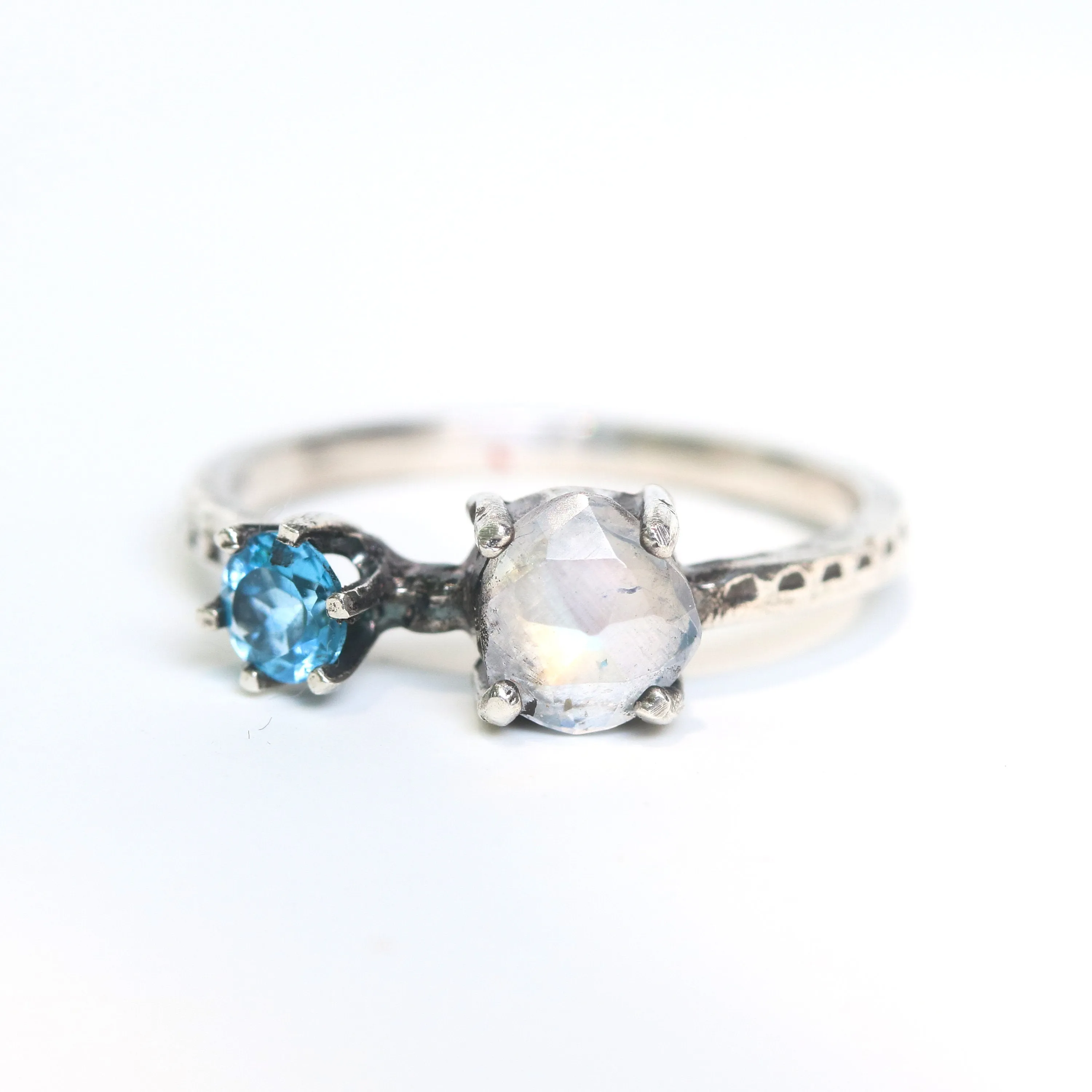 Faceted moonstone ring in silver bezel setting and blue topaz on the side with sterling silver band