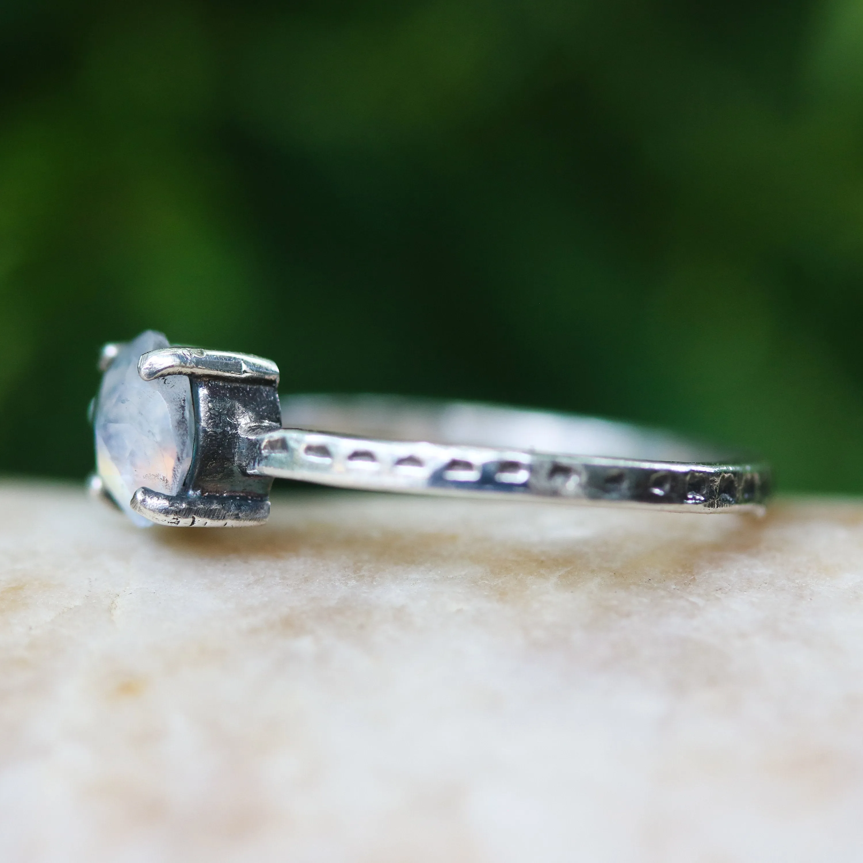 Faceted moonstone ring in silver bezel setting and blue topaz on the side with sterling silver band